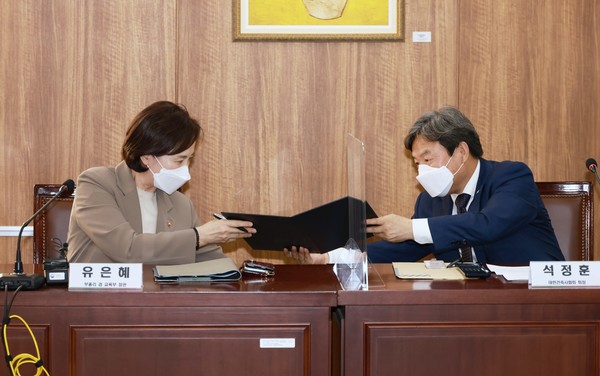 유은혜 교육부총리(왼쪽)과 석정훈 대한건축사협회 회장이 그린스마트 미래학교 사업 협력을 위한 건축 분야 업무협약서에 서명 후 협약서를 교환하고 있다. (사진=교육부)