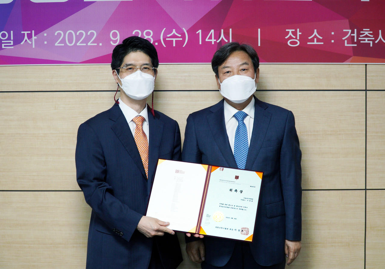 대한건축사협회 중앙윤리위원장에 선임된 서울남부지방법원 이성용 부장판사(왼쪽)가 위촉장을 전달받고 석정훈 본협회장과 기념촬영을 하고 있다.