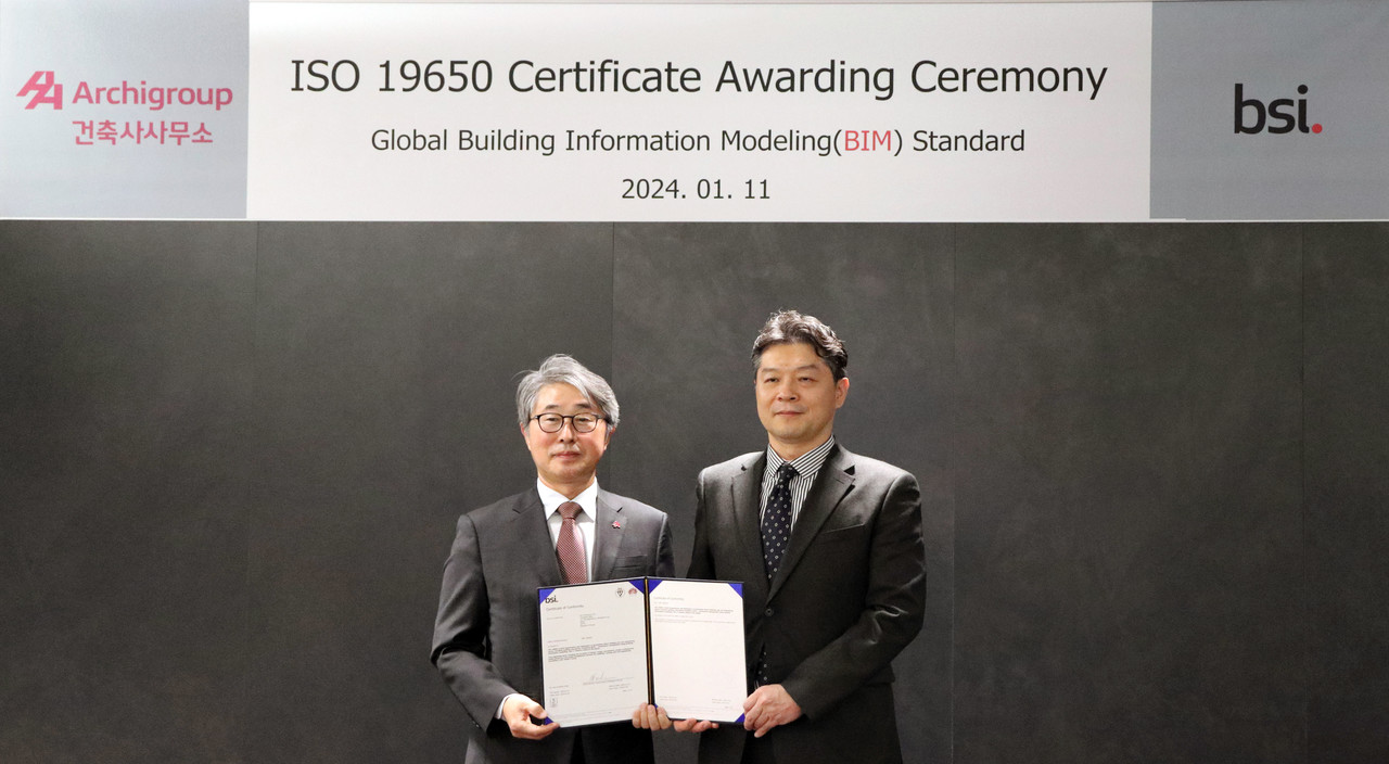 (왼쪽) AA아키그룹건축사사무소 한철욱 대표 건축사가 건축사업계 국내 최초로 받은 ISO 19650 인증서를 들어 보이고 있다. 오른쪽 BSI KOREA 임성환 대표. (사진=AA아키그룹건축사사무소.주)