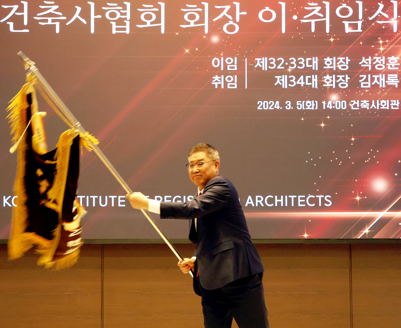 3월 5일 취임한 김재록 제34대 대한건축사협회 회장이 협회기를 흔들고 있다.	(사진=대한건축사협회 건축사신문)