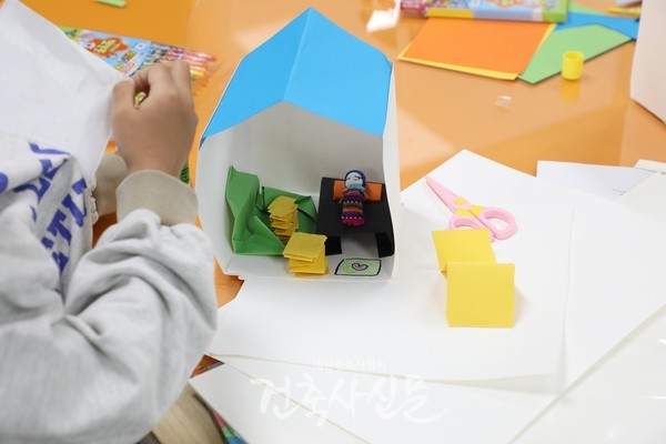 늘봄수업 참여 학생이 걱정인형과 함께 사면체 방을 완성해 가고 있는 모습. (사진=대한건축사협회 건축사신문)