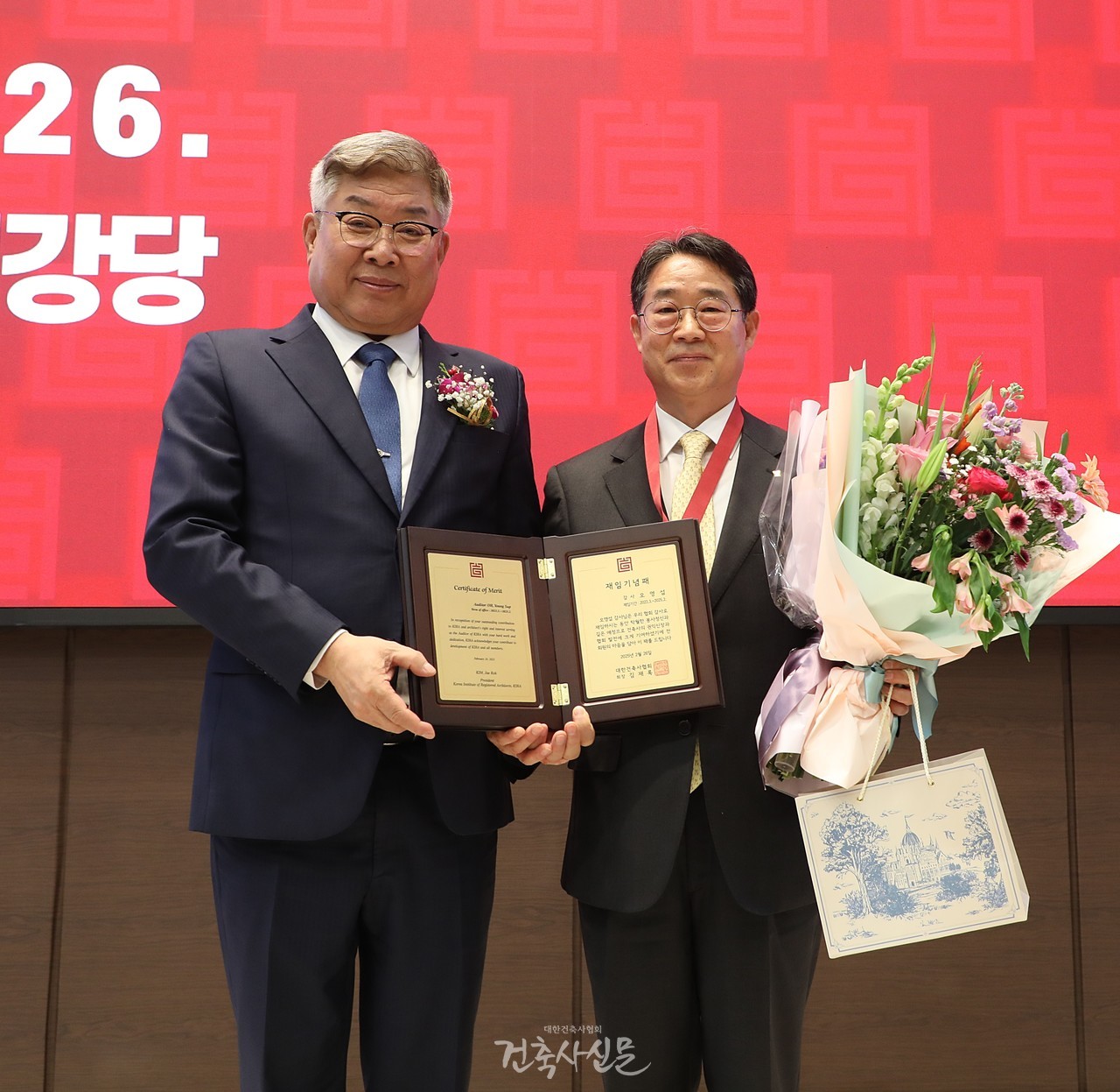 오영섭 감사(오른쪽)가 제59회 대한건축사협회 정기총회에서 재임 기념패를 받고 기념촬영을 하고 있다. (사진=대한건축사협회 건축사신문)