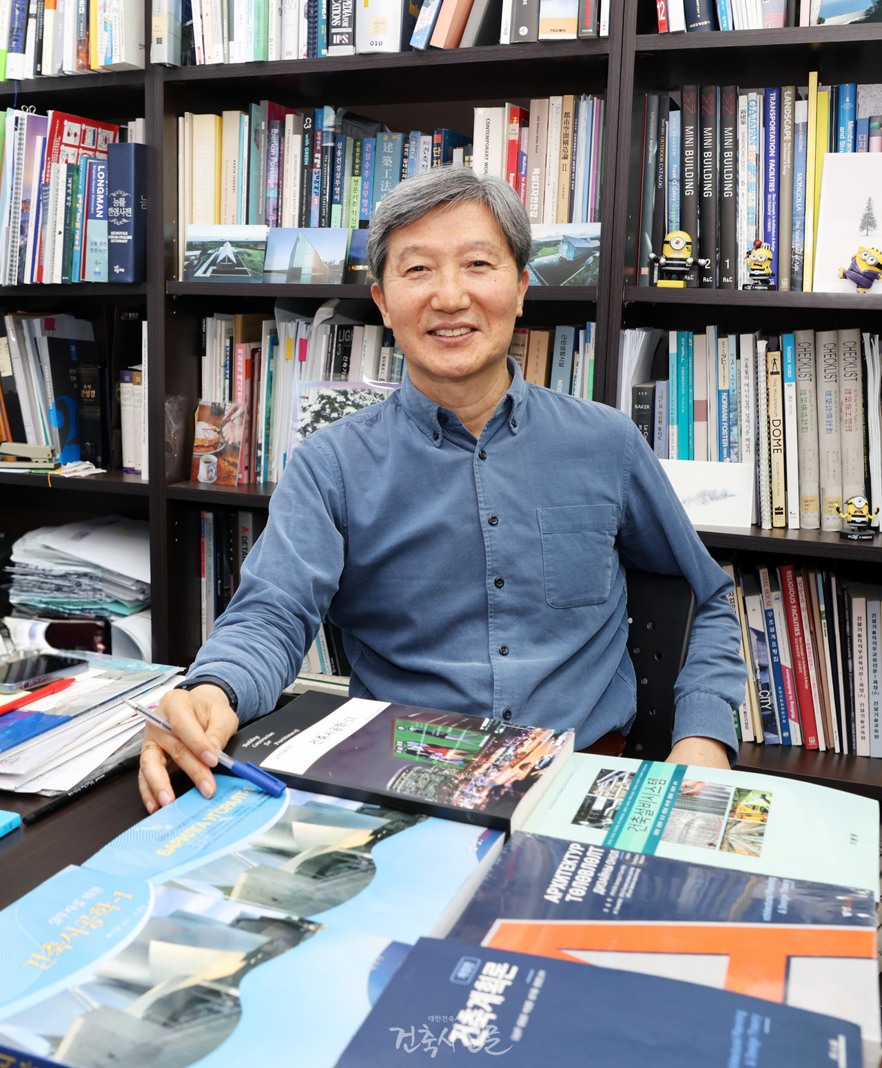 조창곤 건축사(주.경진건축사사무소 대표)가 몽골 건축 교육에 활용되고 있는 교재를 앞에 두고 있다. 교재는 한국의 건축계획 및 시공 내용을 몽골어로 현지화한 것으로, 현재 울란바토르를 포함한 7개 대학에서 공식 교재로 사용되고 있다. (사진=대한건축사협회 건축사신문)